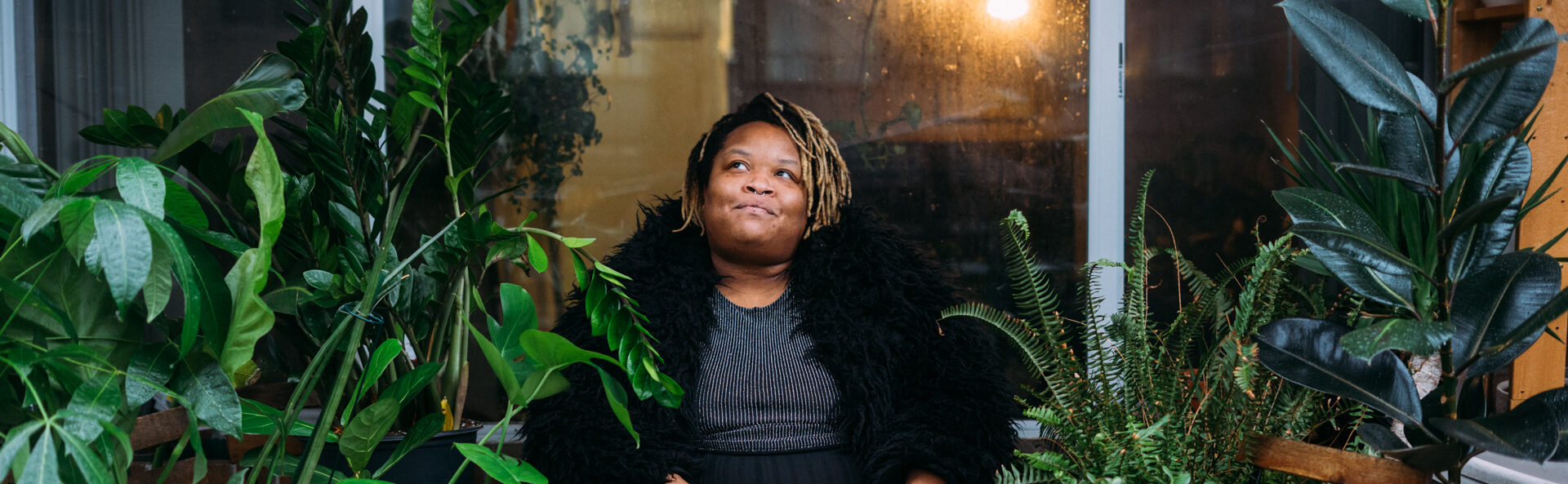 Evana photographed outside surrounded by potted plants