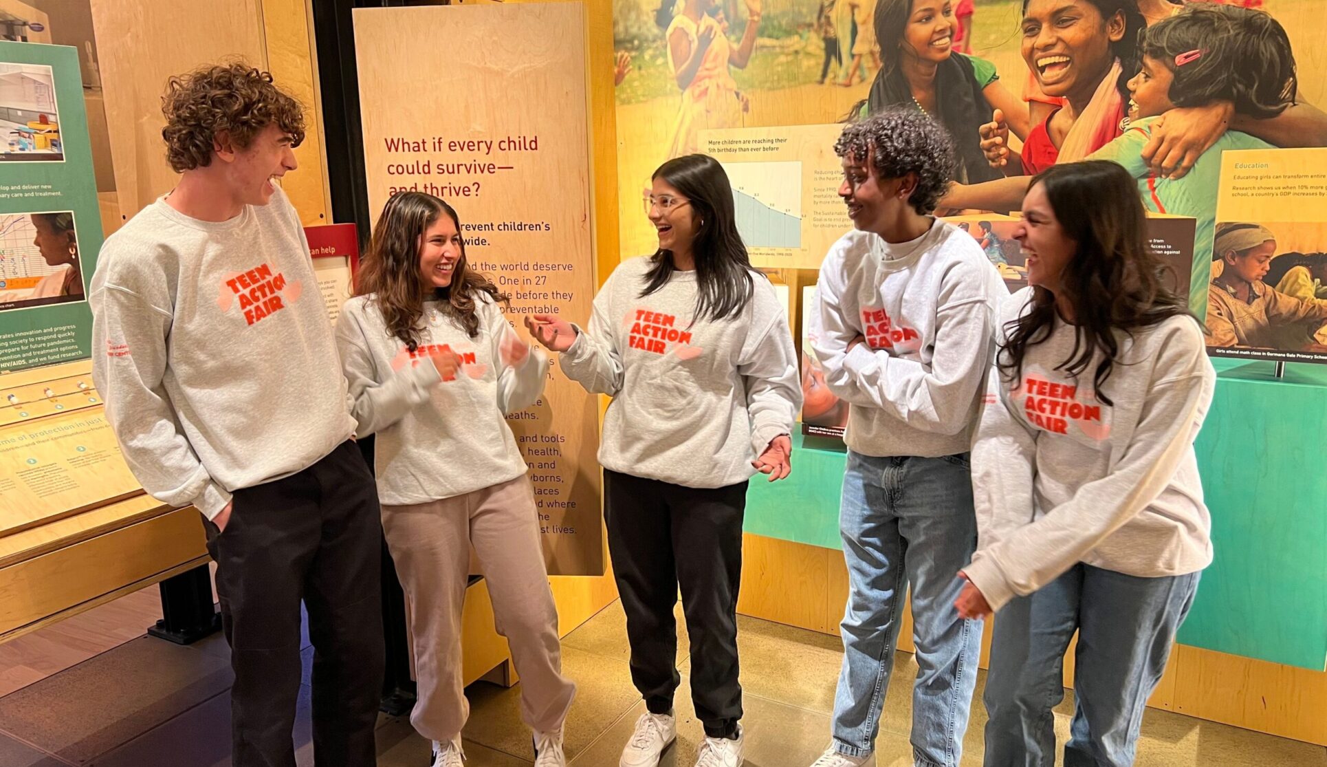 Group of teens talking and laughing in the Discovery Center galleries.