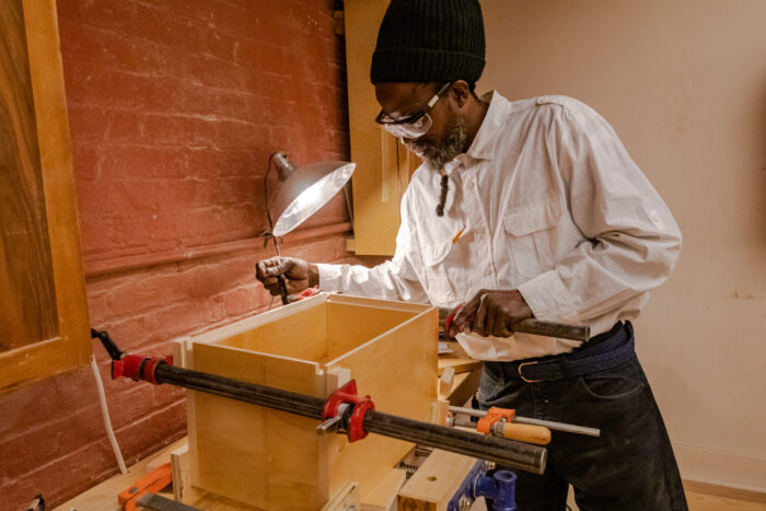 Man in a woodshop building a wooden box.