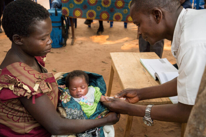 An infant in Africa received a vaccination while being held by its mother.