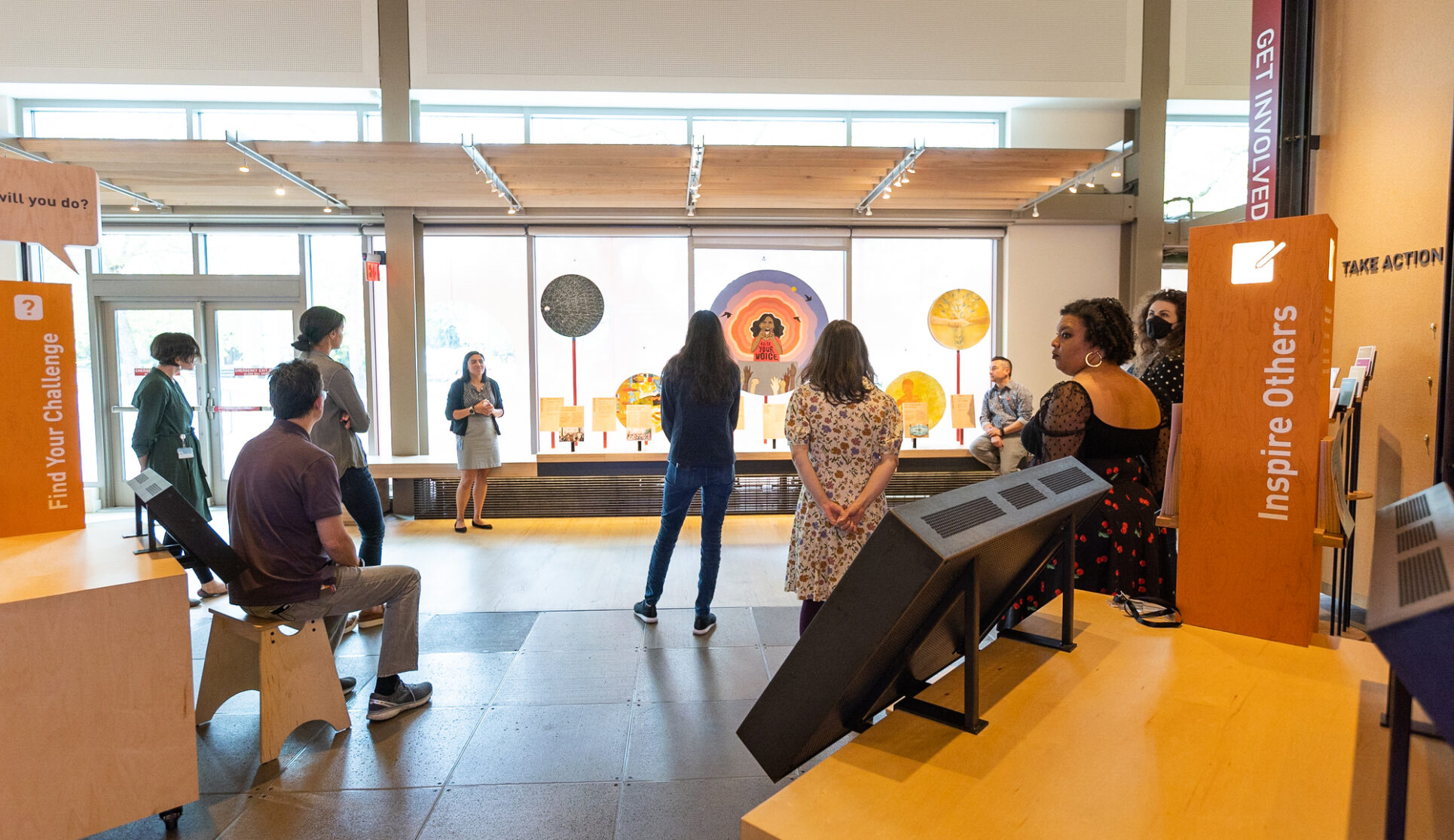 A group of visitors gather around a guide in the gallery as she presents the artist displays at the Bill & Melinda Gates Foundation Discovery Center.