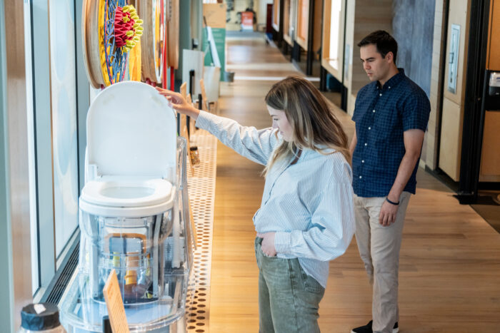 A visitor examines the reinvented toilet on the ramp of the Discovery Center.