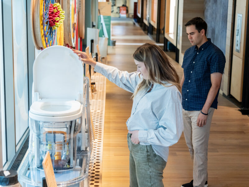 A visitor examines the reinvented toilet on the ramp of the Discovery Center.