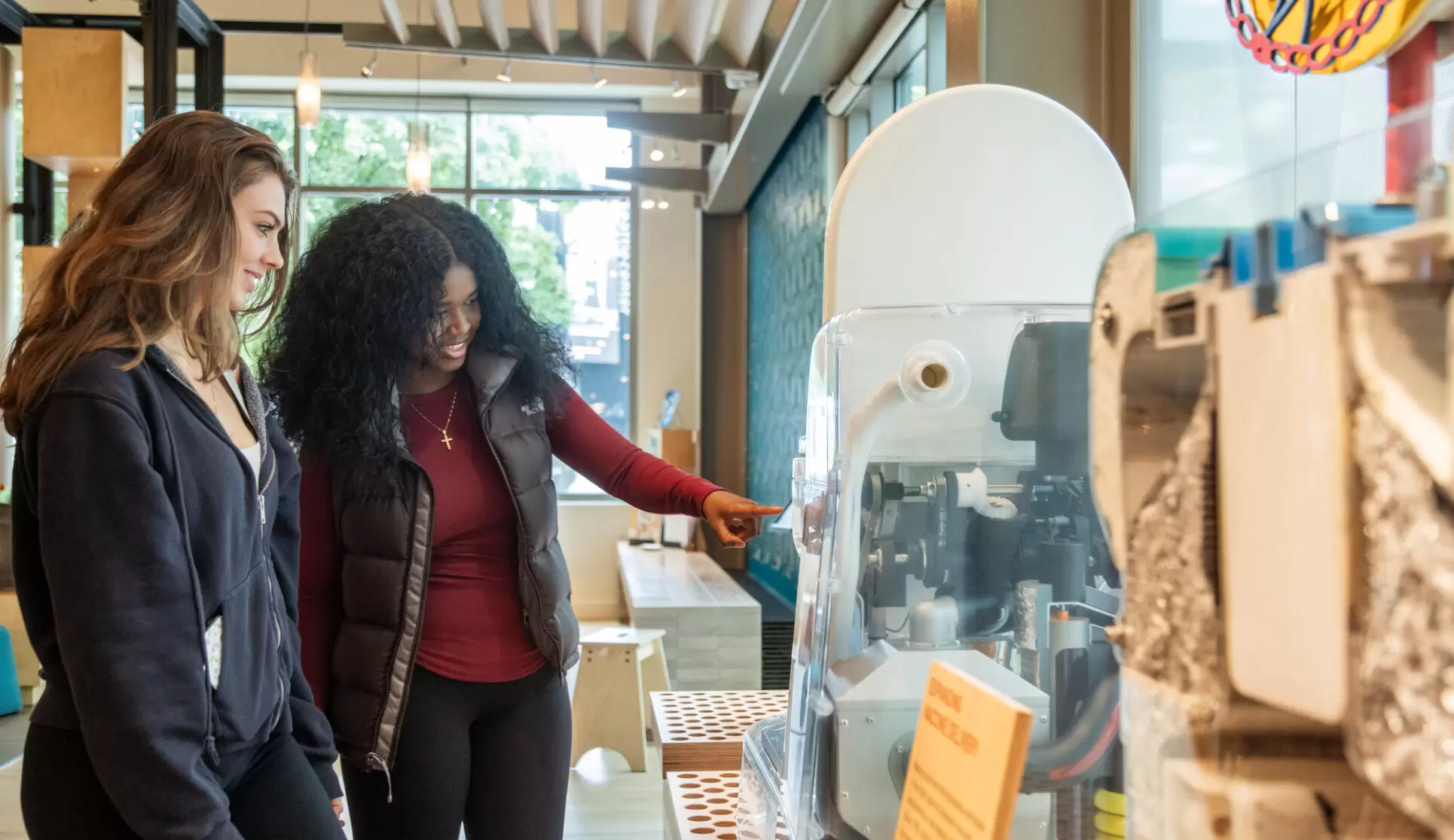 Two young adult visitors examine a reinvented toilet on display at the Gates Foundation Discovery Center.