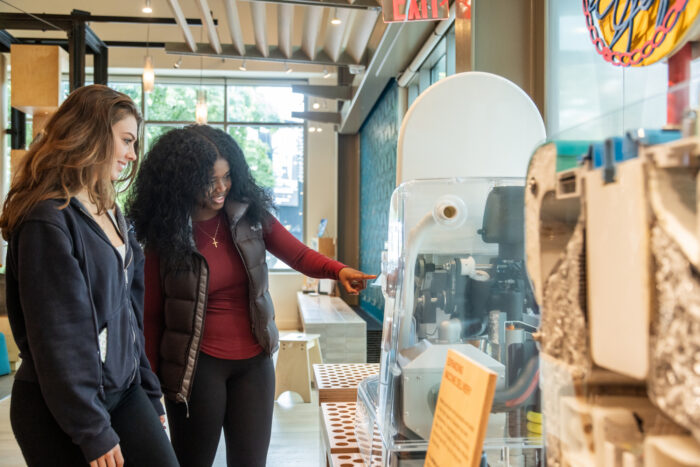 Two young adult visitors examine a reinvented toilet on display at the Bill & Melinda Gates Foundation Discovery Center.