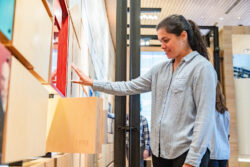 A woman interacting with the moving tiles in the Discovery Center gallery