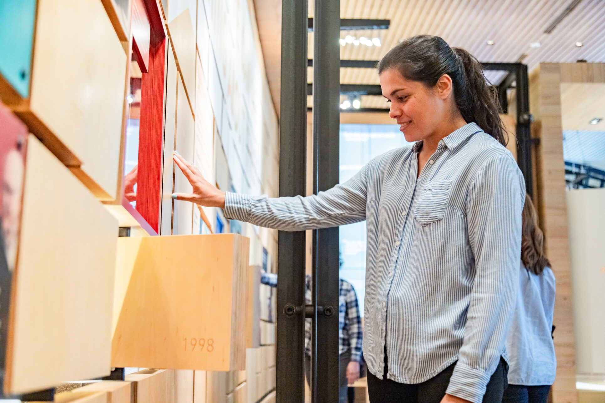 A woman interacting with the moving tiles in the Discovery Center gallery