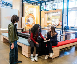 Teen visitors enjoy the "Our Work" gallery in the Discovery Center while interacting with a quiz.