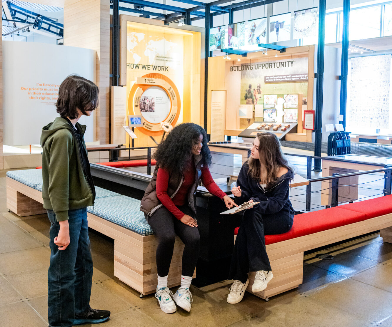 Teen visitors enjoy the "Our Work" gallery in the Discovery Center while interacting with a quiz.