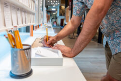 Close-up of a visitor partaking in a written activity at the Discovery Center.