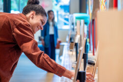 A close-up on a visitor smiling as she examines a display at the Discovery Center.