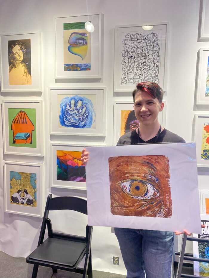 artist standing with artwork