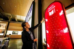 Visitor interacting with an exhibition display at the Discovery Center