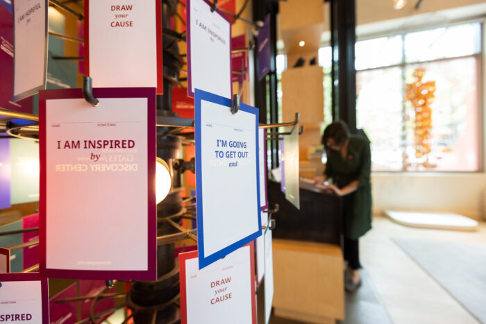 Close up of the share your cause rack in the Discovery Center. Visitors can personalize a card and hang on the rack during their visit.