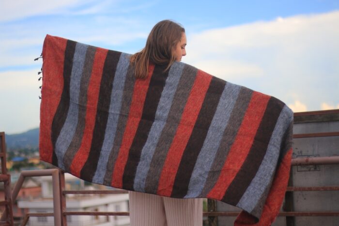 Woman holding up a blanket across her back