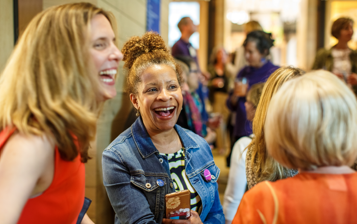 Women chatting and laughing together at the Discovery Center.