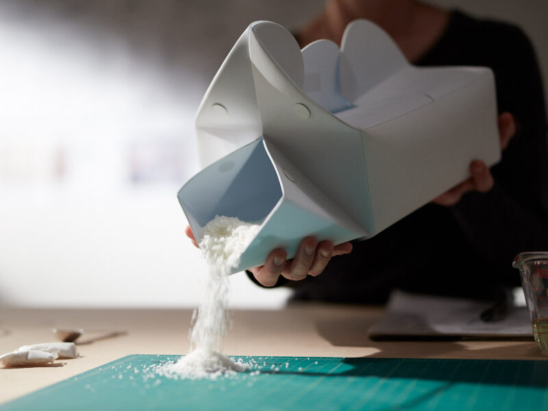 the night loo box powder being poured out onto a table.