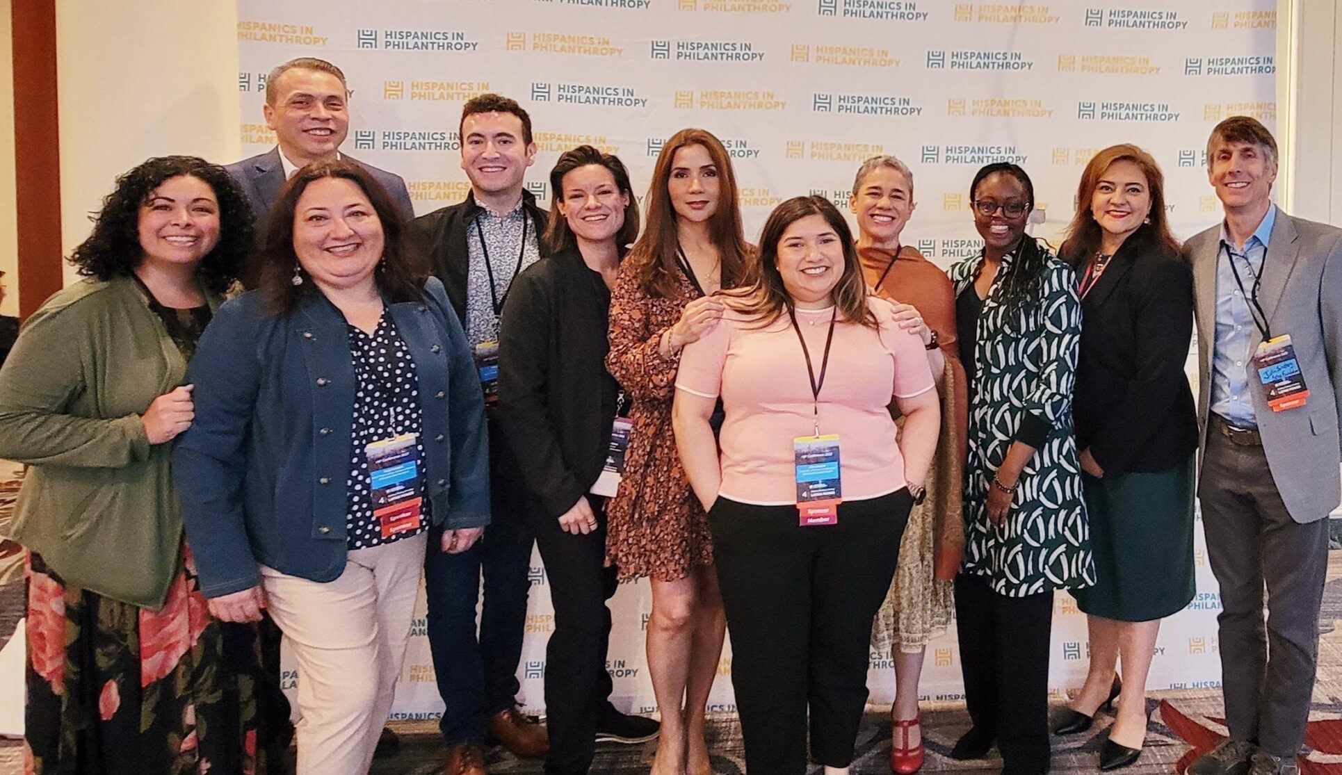 A group of foundation employees stand together smiling for a photo at an event