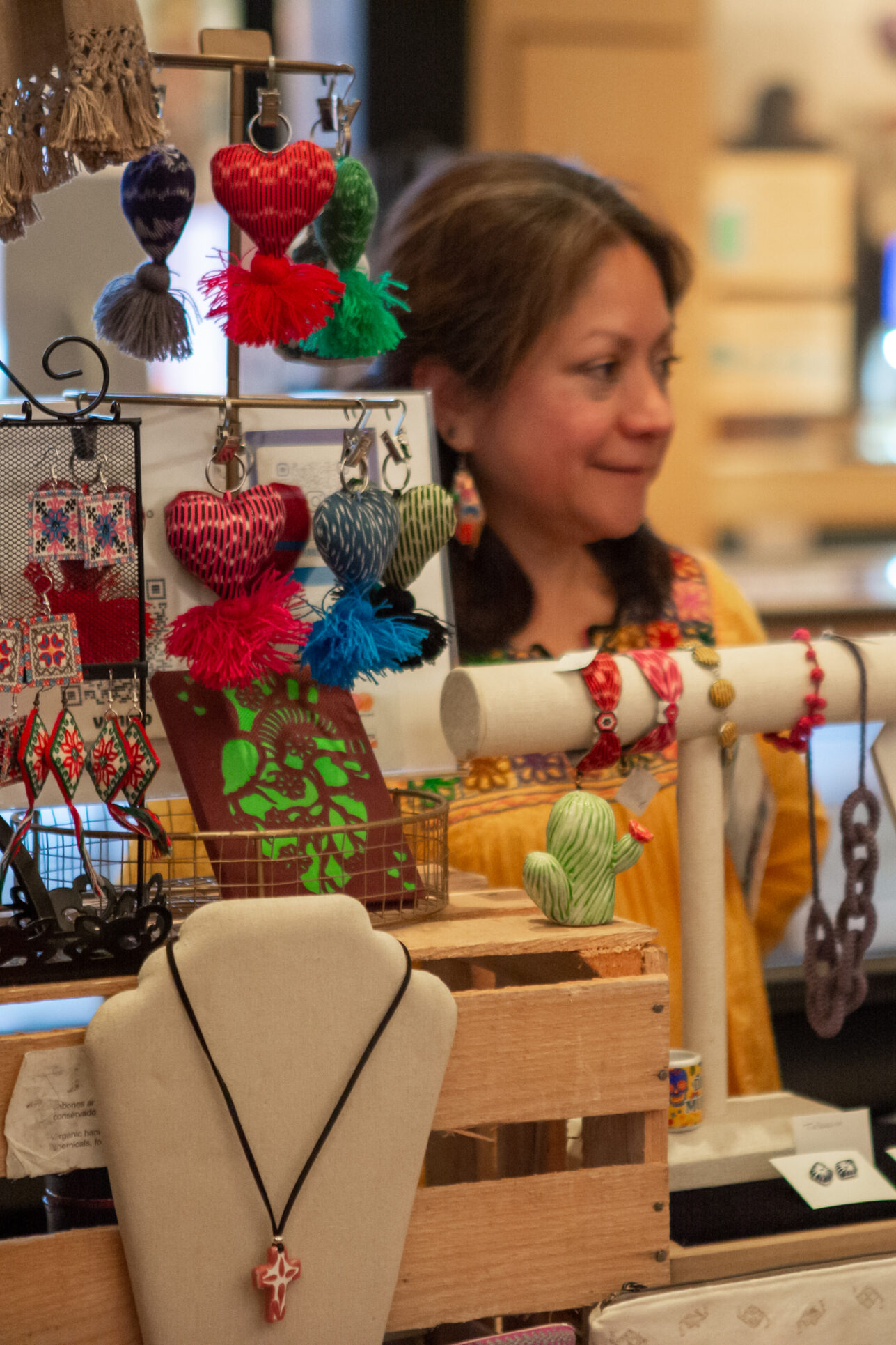 Visitor visits vendor's table and shops holiday gifts that give back during the annual Giving Marketplace