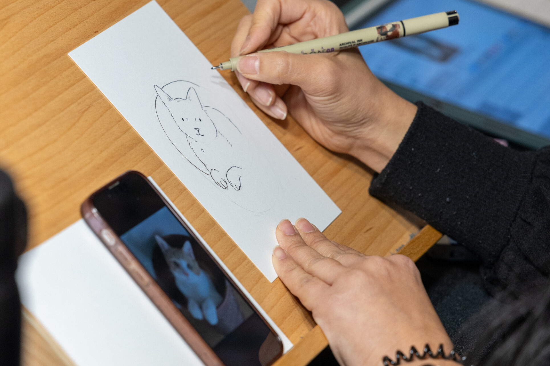 Cathy Wu drawing pet portraits at Giving Marketplace.