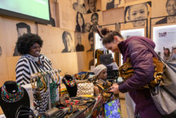 Vendor smiling at visitor as they present their products