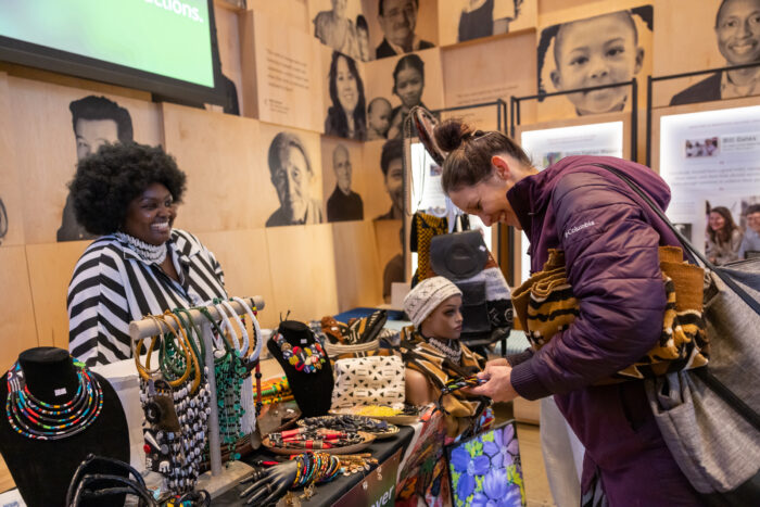 Vendor smiling at visitor as they present their products