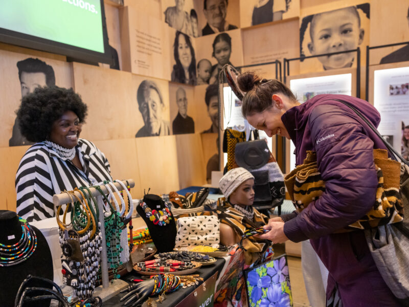 Vendor smiling at visitor as they present their products