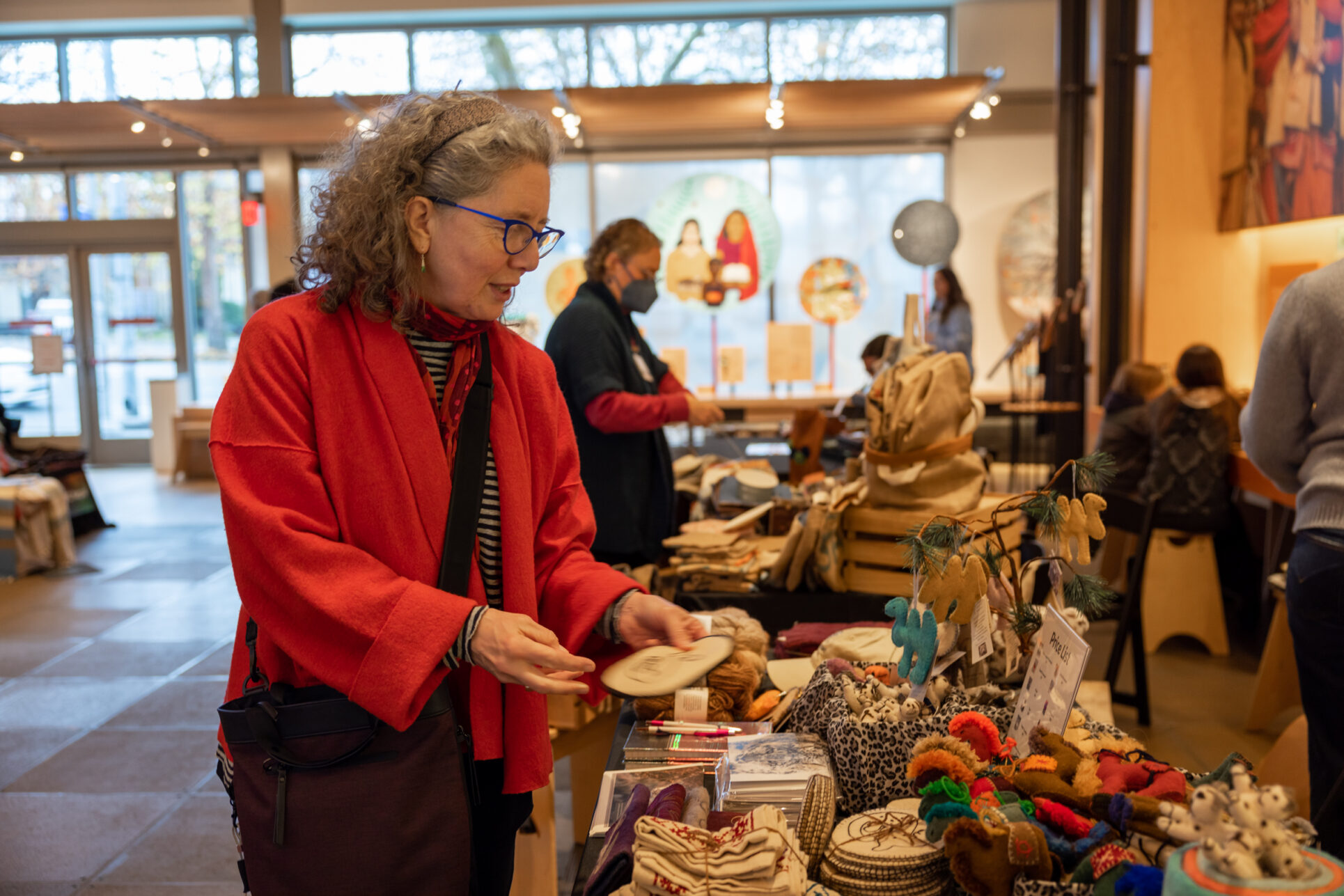 Visitor visits vendor's table and shops holiday gifts that give back during the annual Giving Marketplace