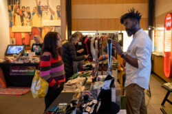 Vendor smiling at visitor as they present their products