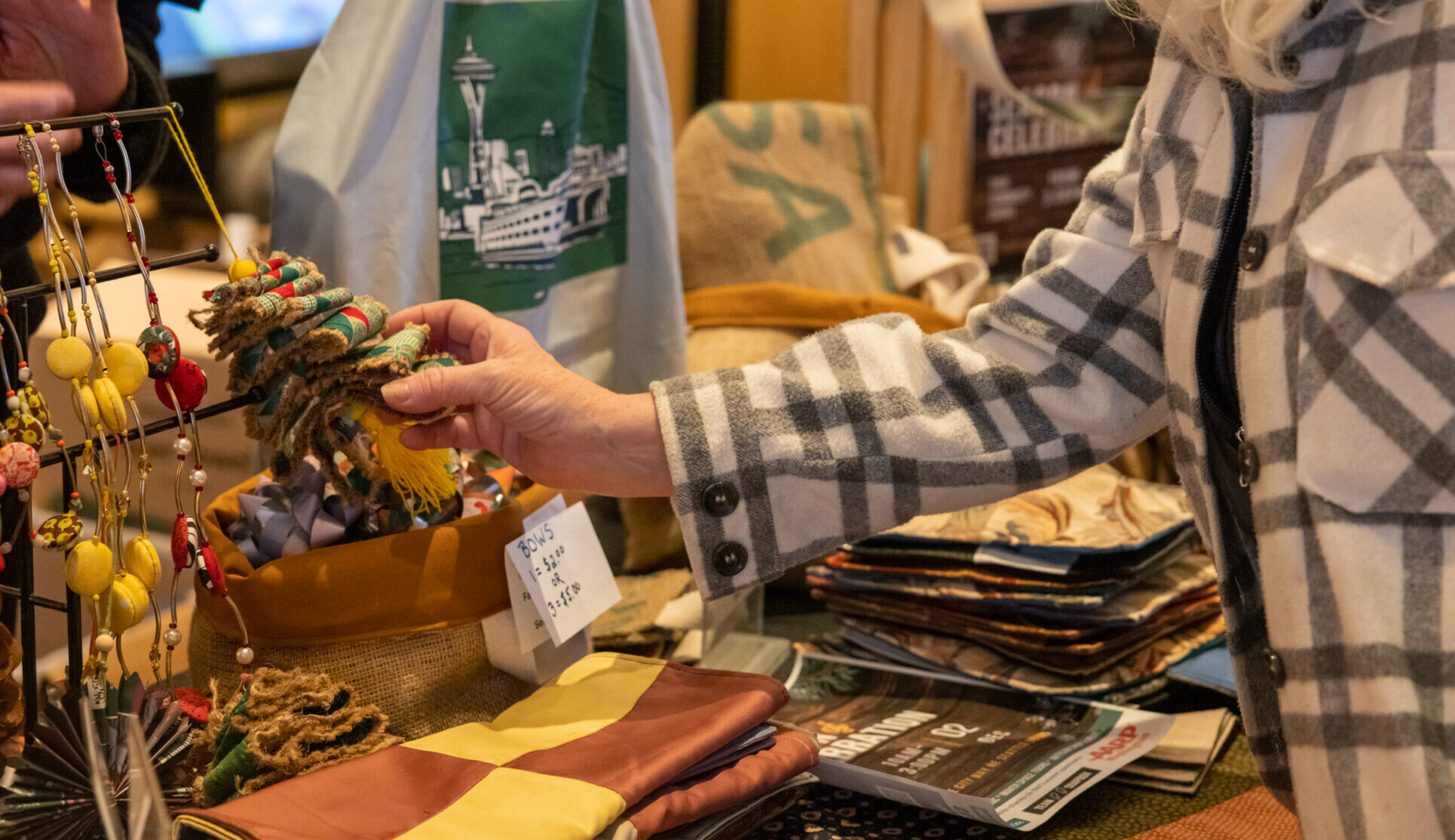 Visitor visits vendor's table and shops holiday gifts that give back during the annual Giving Marketplace