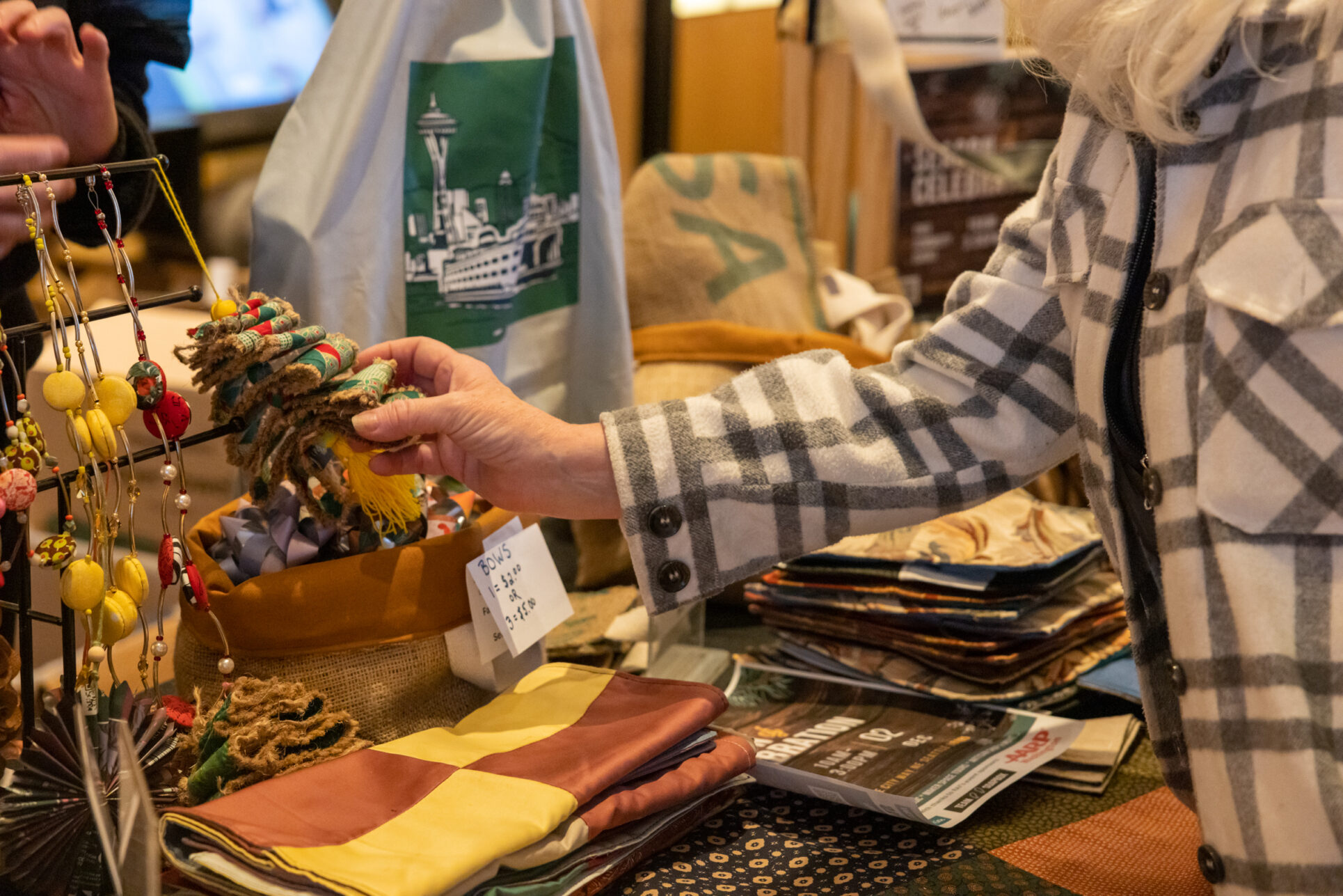 Visitor visits vendor's table and shops holiday gifts that give back during the annual Giving Marketplace