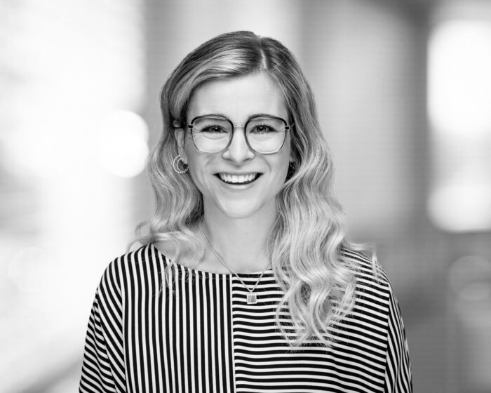 McKenna Rector, smiles to thh camera in a black and white photo.