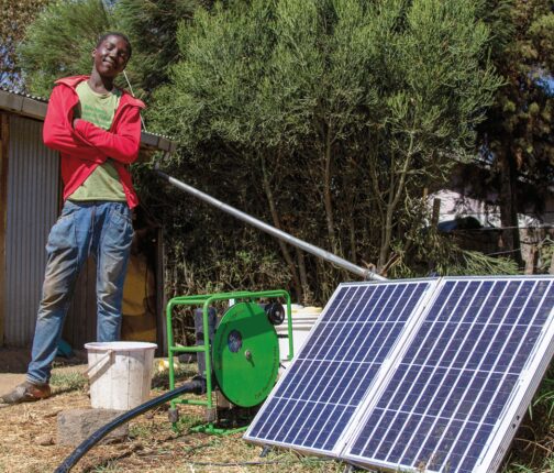 Farmers stand by solar-powered irrigation system.