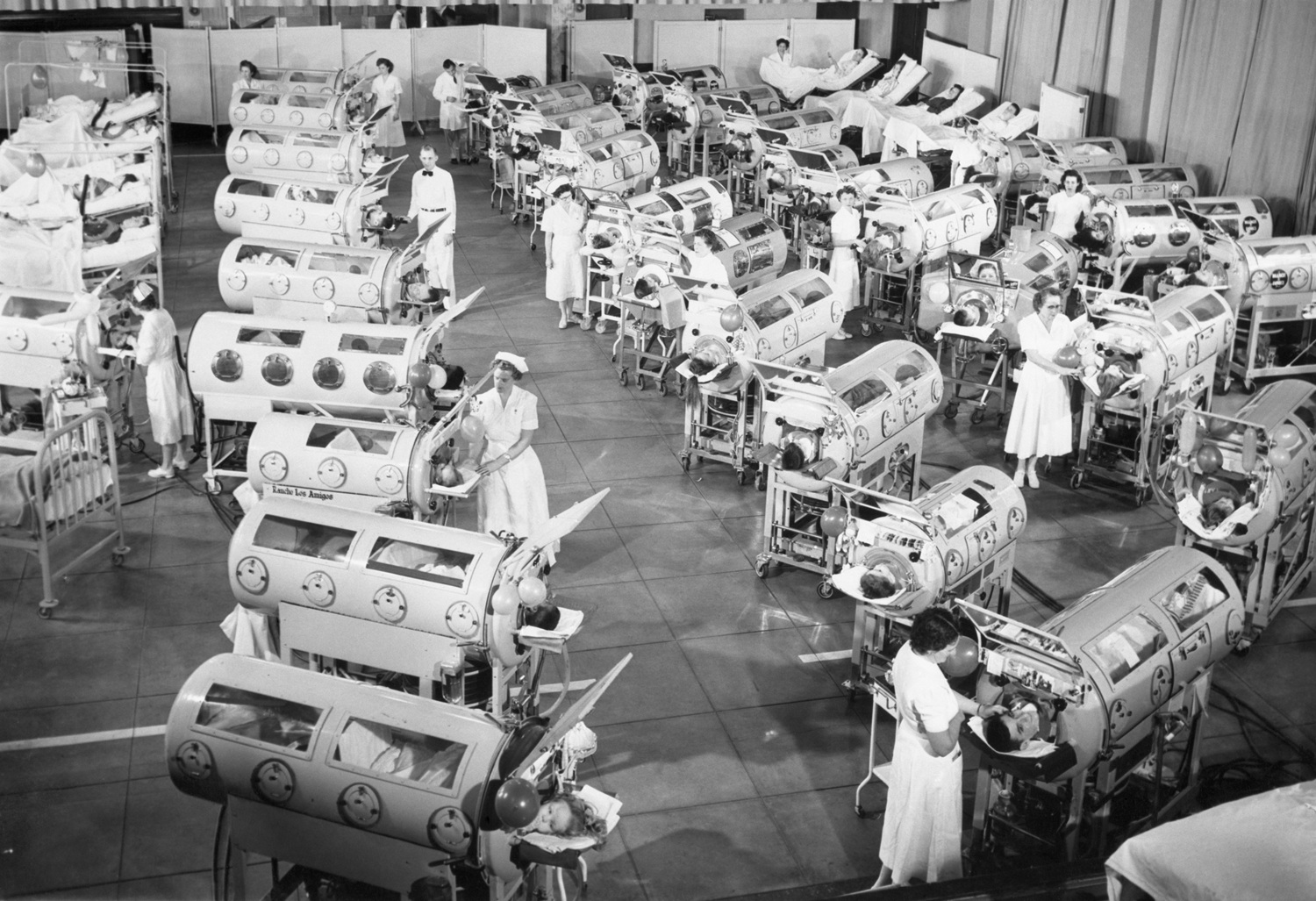 Black and white images of Iron Lungs in a Polio Ward.