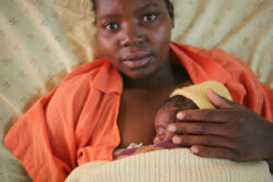 A mother uses kangaroo mother care with her newborn while in bed.
