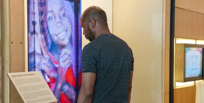 Visitor looks on at the "Sense of Hope" AI art installation at the Discovery Center.