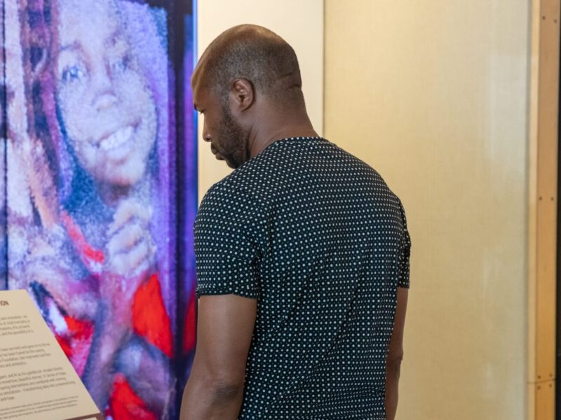Visitor looks on at the "Sense of Hope" AI art installation at the Discovery Center.