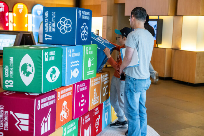 Visitors play with global goal blocks at the discovery center